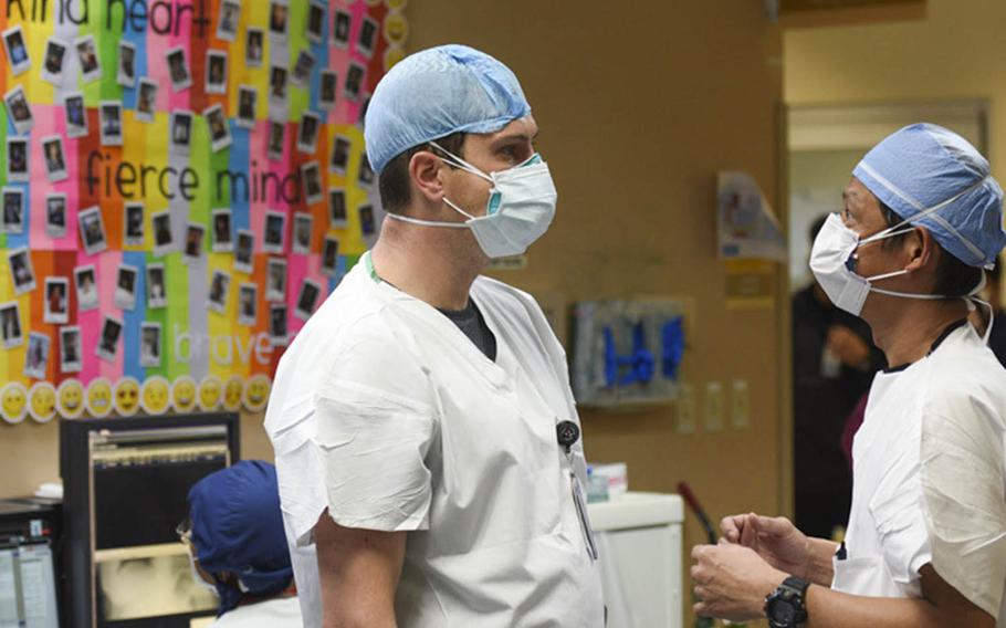 Army Capt. Owen Caron, left, a critical care nurse, reviews procedures with staff at Guam Memorial Hospital, Sept. 28, 2020.
