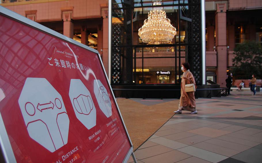 A sign in central Tokyo reminds pedestrians to protect themselves against the coronavirus, Nov. 17, 2020. 