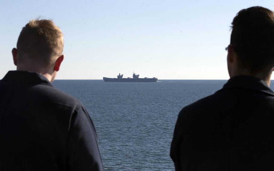 USS Gerald R. Ford sailors watch as the British Royal Navy aircraft carrier Queen Elizabeth steams through the Atlantic Ocean, Nov. 25, 2019. 