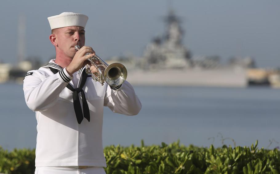 A U.S. Navy sailor plays taps in front of the USS Missouri during a ceremony to mark the anniversary of the attack on Pearl Harbor, Monday, Dec. 7, 2020, in Pearl Harbor, Hawaii. 