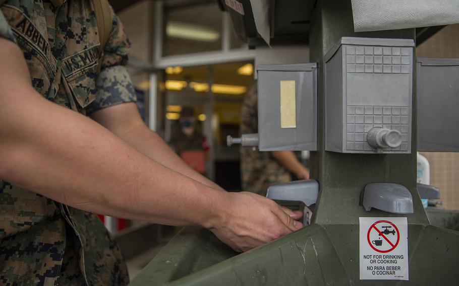 Lance Cpl. Abben Nicholas, of the III Marine Expeditionary Force Support Battalion, uses a hand-washing station earlier this year at Camp Hansen, Okinawa. 