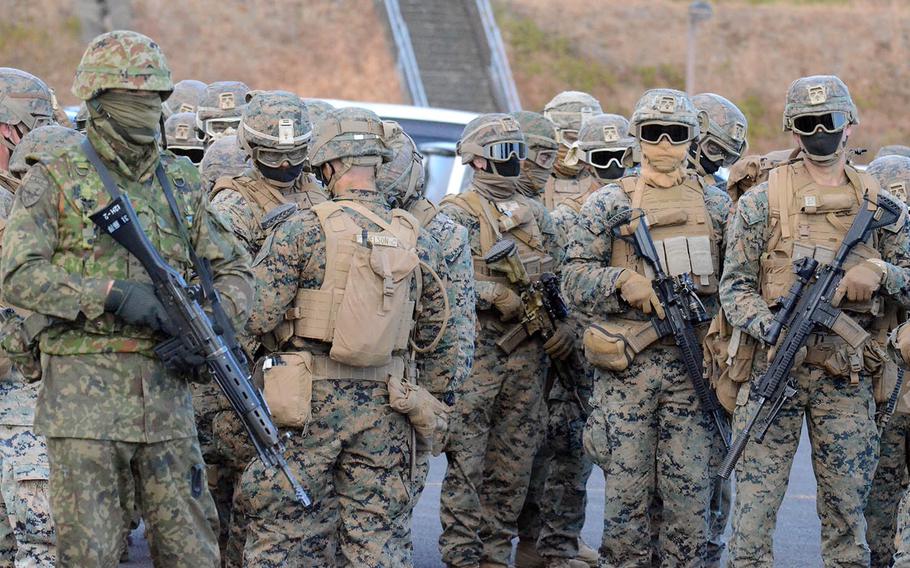 U.S. Marines and Japanese Ground Self-Defense Force soldiers prepare for an air assault exercise at Soumagahara Training Area in Gunma prefecture, Japan, Tuesday, Dec. 15, 2020. 