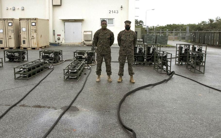 Chief Warrant Officer 3 Todd Coyle, right, and Gunnery Sgt. Alex Wright work on their Lightweight Water Purification System 3.0 at Camp Hansen, Okinawa, Dec. 7, 2020.
