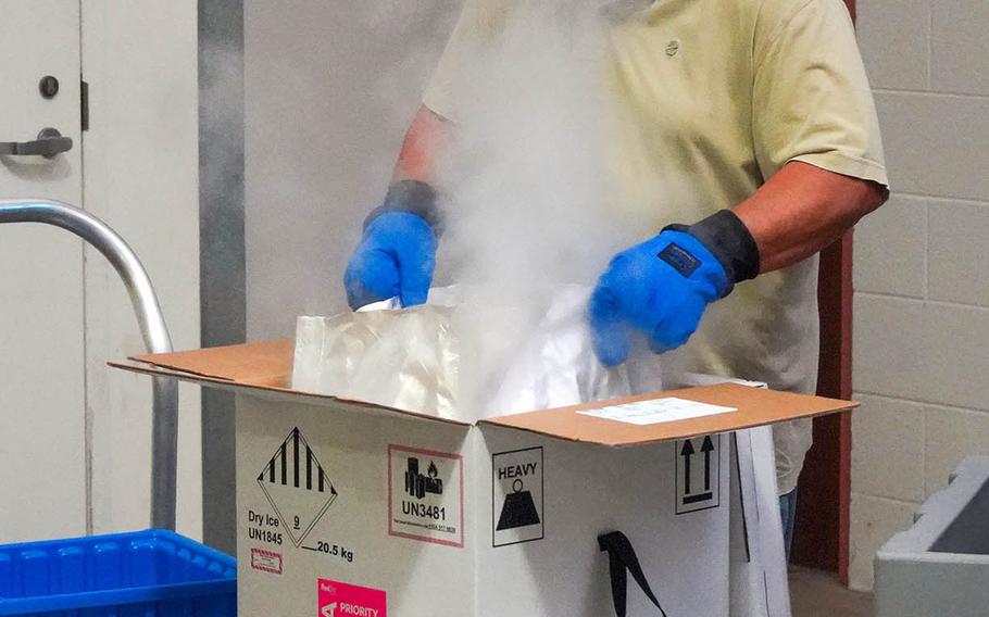 Norberto Seda-Ortiz, a member of Tripler Army Medical Center's Logistics Division, unpacks the Hawaii facility's first shipment of coronavirus vaccine from its dry-ice container, Tuesday, Dec. 15, 2020.

