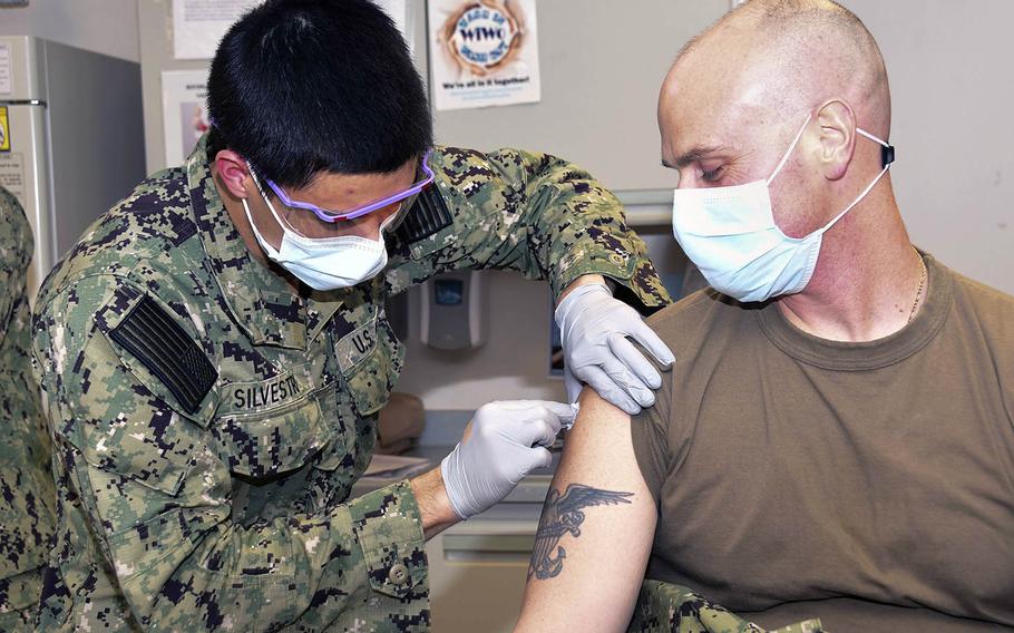 Navy Hospitalman Roman Silvestri administers a coronavirus vaccine to Cmdr. Joseph Kotora at Naval Medical Center Portsmouth, N.H., on Dec. 15. Vaccines are coming soon to six installations in Japan, U.S. Forces Japan announced Dec. 20.