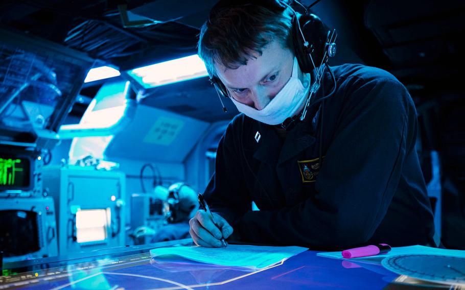 U.S. Navy Lt. Christopher Baier, from Cheboygan, Mich., logs anti-submarine warfare reports while standing watch aboard the guided-missile destroyer USS John S. McCain in the Philippine Sea on Dec. 16, 2020. 