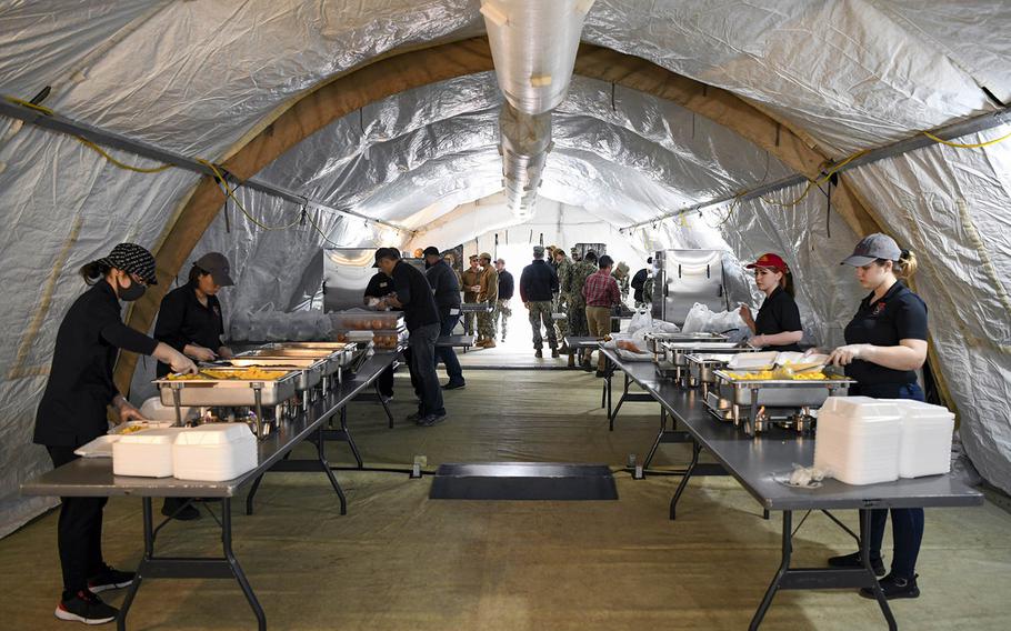 Sailors and airmen prepare food for personnel in isolation due to coronavirus restrictions at Naval Air Facility Misawa, Japan, on April 1, 2020.