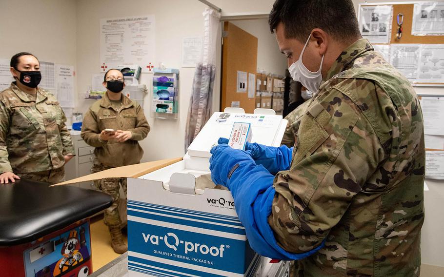 Staff Sgt. Daniel Monzon-Kazhe, 374th Medical Group, holds a box of Moderna COVID-19 vaccines at the immunization office on Yokota Air Base, Japan, Dec. 26, 2020.