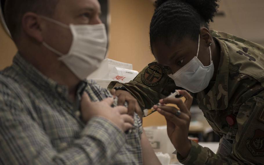 Air Force Staff Sgt. Shakeyla Moses, 25, from Columbus, Ga., administers the Moderna coronavirus vaccine to Col. Dane Campbell, medical group deputy commander at Yokota Air Base, Japan, on Monday, Dec. 28, 2020. 