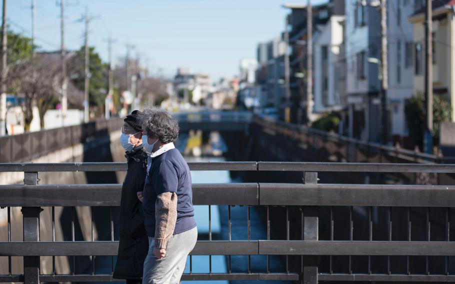 Women strolling through a section of Tokyo are wearing masks to prevent coronavirus inections on Dec. 21, 2020. 