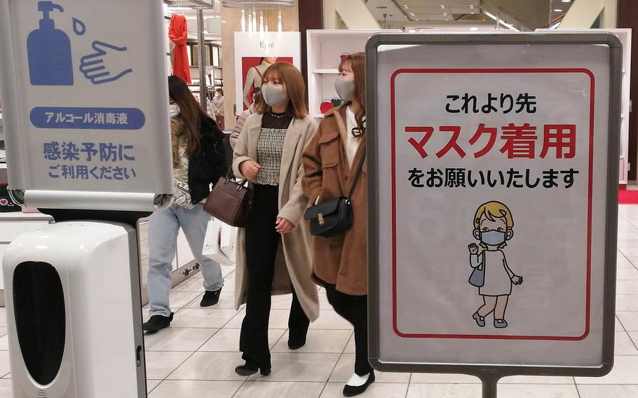 Signs in the shopping area near Yokohama Station remind passersby of preventive measures against the coronavirus on Dec. 21, 2020.