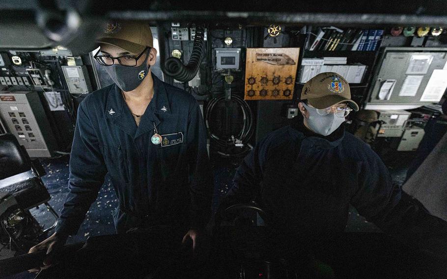 Boatswain's Mate 3rd Class Jonni Melo, left, from Bronx, N.Y., and Boatswain's Mate 3rd Class Nicole Zapata, from Tampa, Fla., stand watch in the pilot house aboard USS John S. McCain in the Taiwan Strait on Wednesday, Dec. 30, 2020. 
