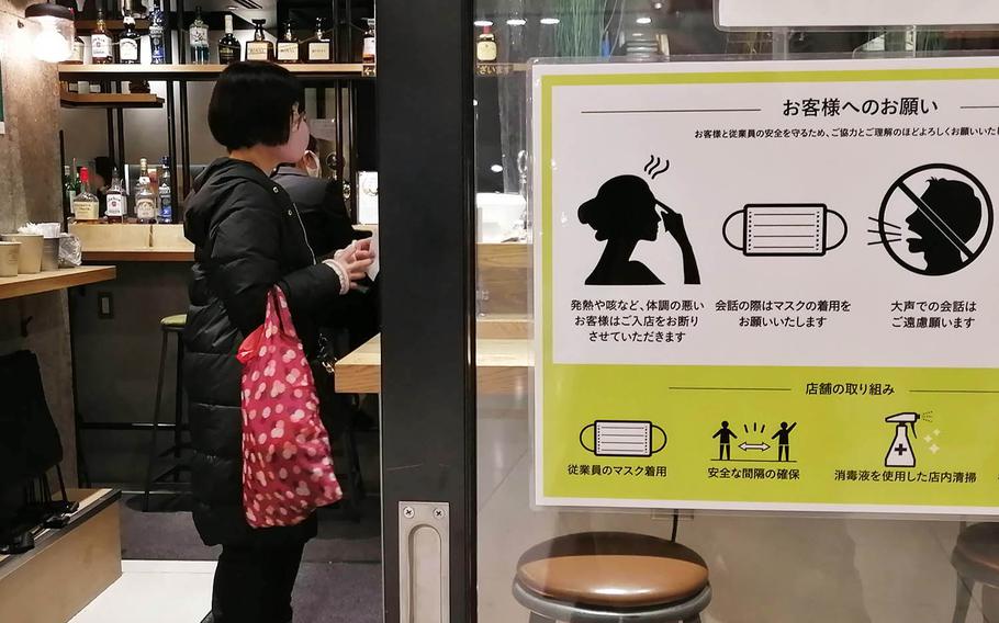 Signs in a shopping area near Yokohama Station urge passersby to observe coronavirus prevention measures on Dec. 21, 2020.