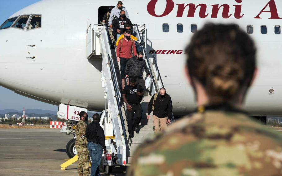 U.S. service members and their families exit the Patriot Express at Osan Air Base, South Korea, Wednesday, Oct. 28, 2020.
