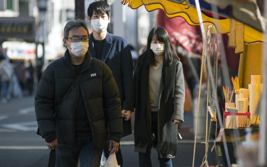 Visitors to Kawasaki-Daishi temple in Kanagawa prefecture, Japan, wear masks while strolling past souvenir and food stands on Jan. 4, 2021.

