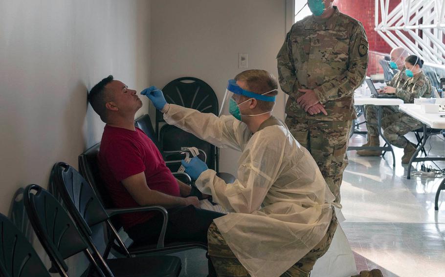 Air Force Chief Master Sgt. Jason France, center right, observes Staff Sgt. Travis Chadwick as he tests a passenger for COVID-19 at Baltimore Washington International Thurgood Marshall Airport, Nov. 9, 2020. 