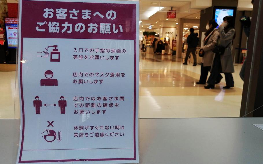 A store in Yokohama, Japan, displays signs encouraging customers to take measures to prevent a coronavirus infection on Jan. 6, 2021. 