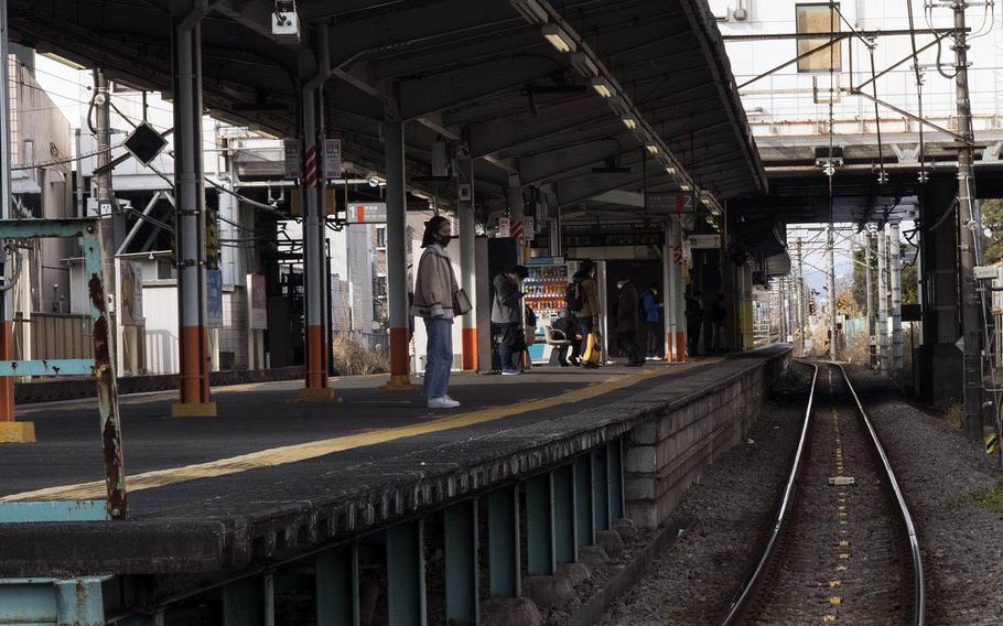 A lone, masked traveler waits for a train in Fussa, near Yokota Air Base, Japan, Jan. 5, 2020. 