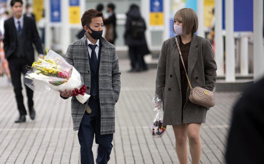 Yokohama pedestrians wear masks en route to Japanese coming-of-age ceremonies, Monday, Jan. 11, 2021.