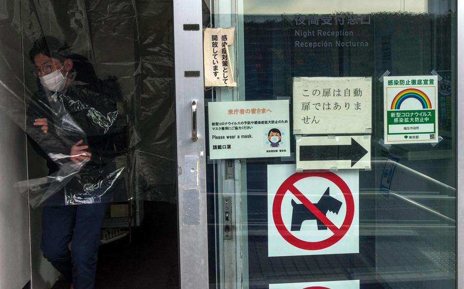 A shopper wears a mask to guard against the coronavirus while leaving a store in Fussa, Japan, Jan. 5, 2020. 