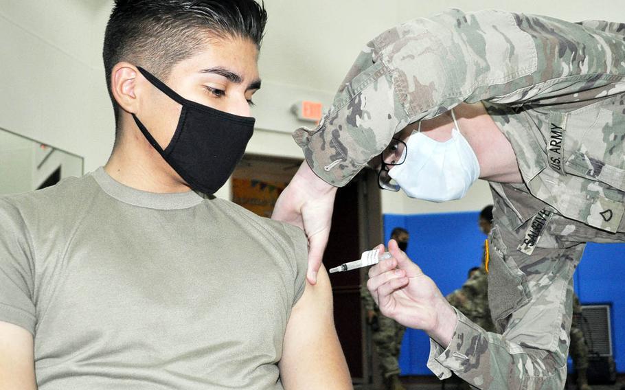 Jan. Pfc. Nathan Salsgiver gives the coroanvirus vaccine to Pvt. Rodrigo Grimaldo at Camp Zama, Japan, Jan. 6, 2021.