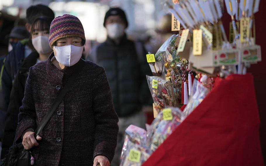 People wear masks early this month while visiting Kawasaki-Daishi, a Buddhist temple in Kawasaki, Japan. 