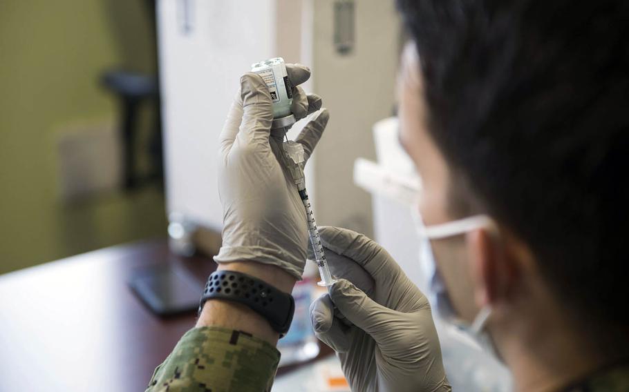 A hospital corpsman assigned to Naval Hospital Yokosuka prepares a coronavirus vaccine at Yokosuka Naval Base, Japan, Jan. 5, 2021. 