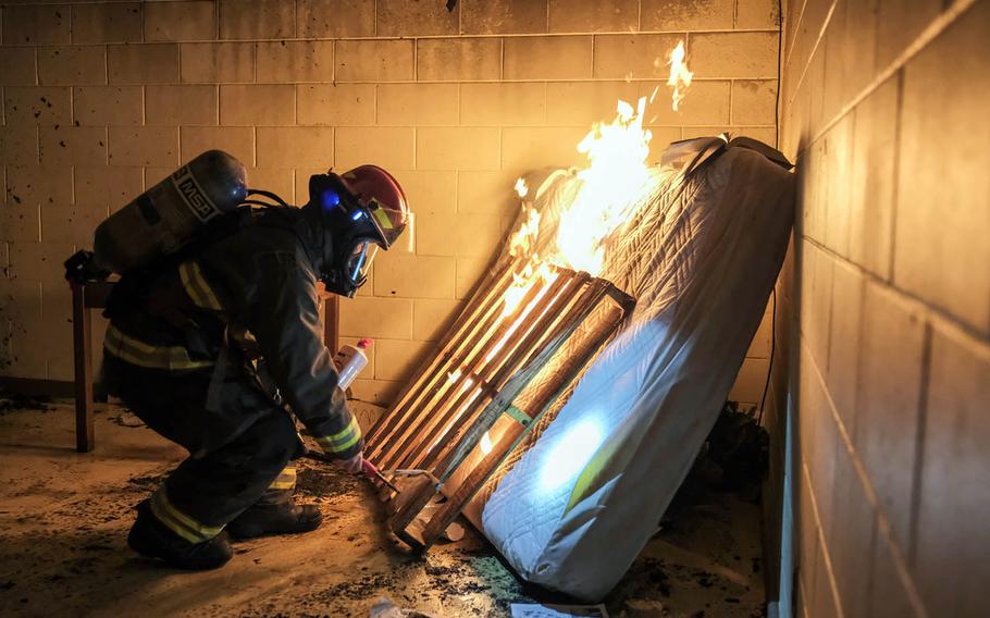 Tech. Sgt. Peter Beyer ignites old furniture inside a condemned dormitory for training at Osan Air Base, South Korea, Jan. 22, 2021.
