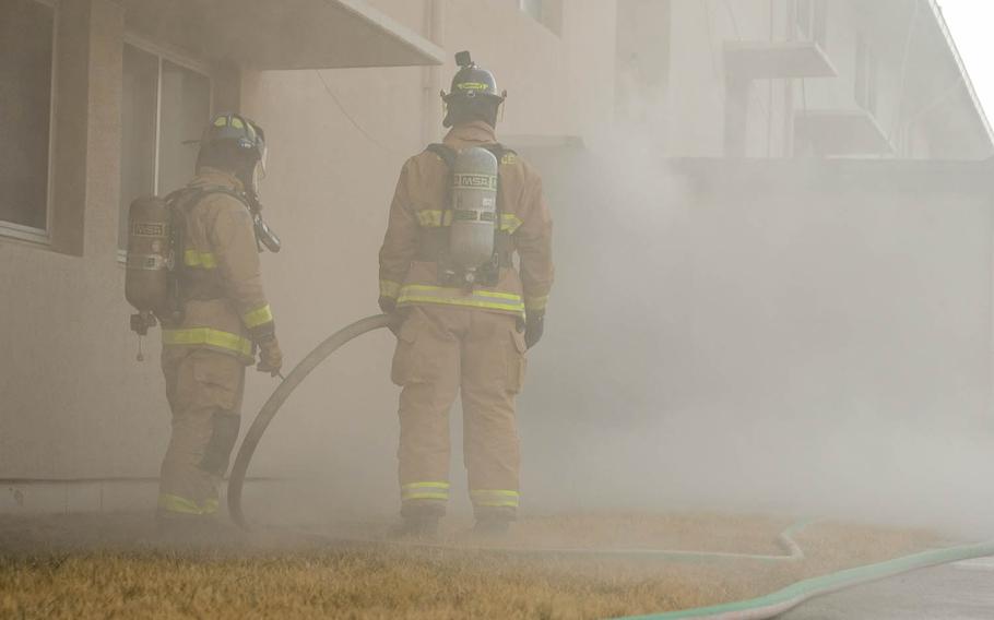 Firefighters with the 51st Fighter Wing guide a firehose for teammates inside a burning dormitory during training at Osan Air Base, South Korea, Jan. 22, 2021.
