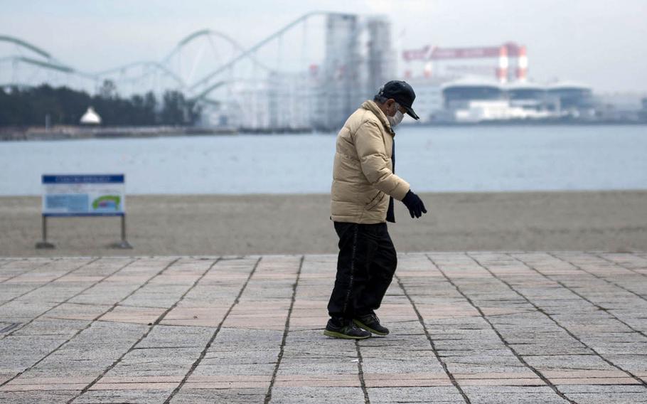 A man wears a mask to guard against the coronavirus while walking in Yokohama, Japan, Jan. 26, 2021. 
