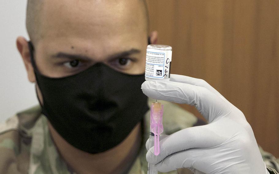 Tech Sgt. Defabian Johnson, an 18th Medical Group pharmacy technician, loads a syringe with a dose of the Moderna coronavirus vaccine at Kadena Air Base, Okinawa, Friday, Jan. 29, 2021.