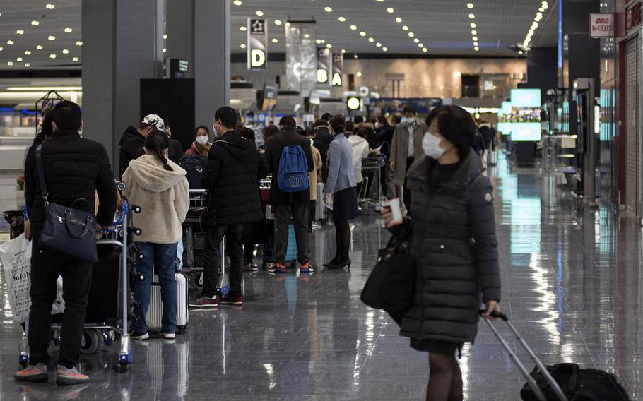 Travelers wear masks inside a departure terminal at Narita International Airport east of Tokyo, Jan. 15, 2021. 
