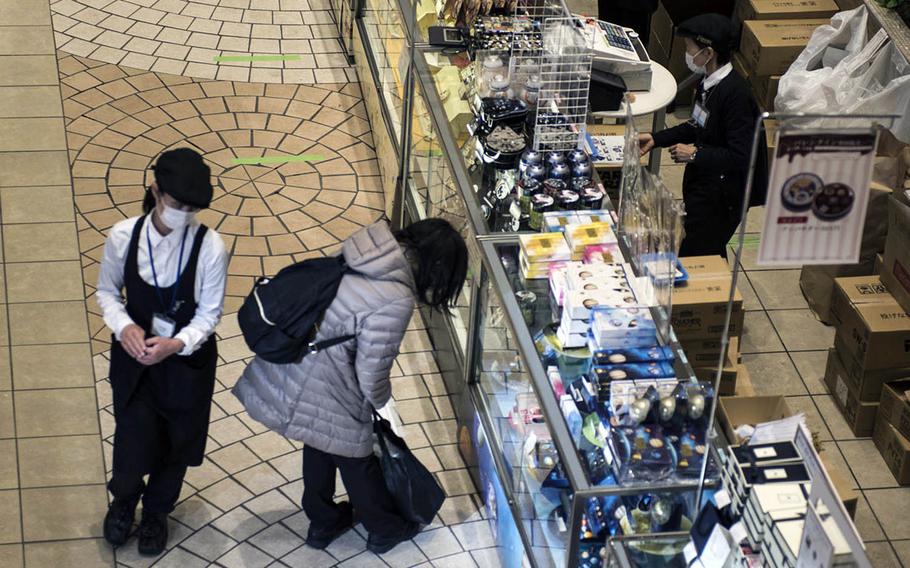Clerks mask themselves againt the coronavirus at department store in Hachioji, Japan, Tuesday, Feb. 2, 2021. 