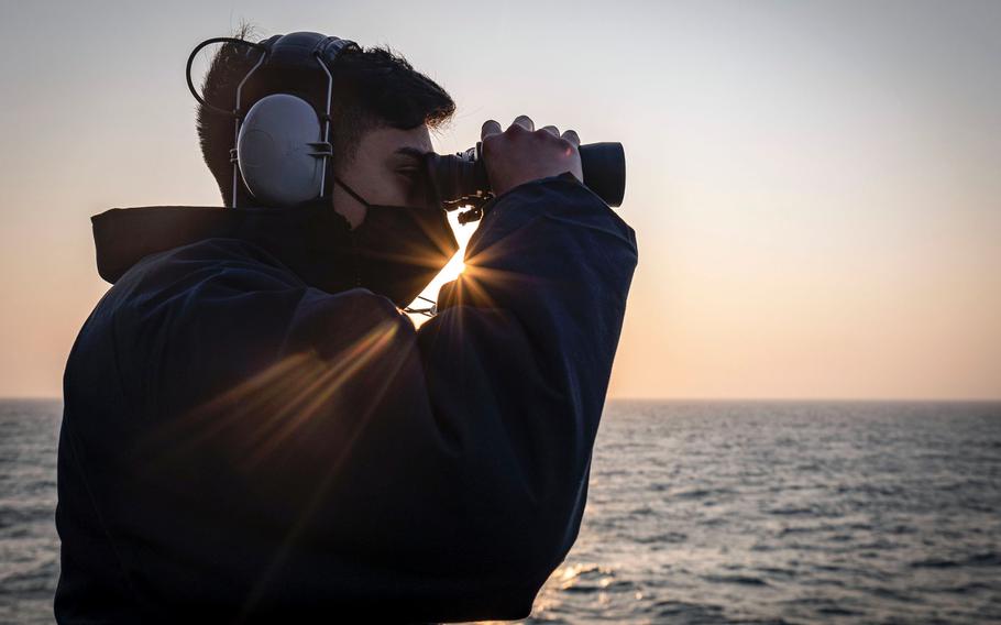 Seaman Frank Medina of Dallas, Texas, scans the horizon from the bridge of the guided-missile destroyer USS John S. McCain in the Taiwan Strait, Thursday, Feb. 4, 2021. 