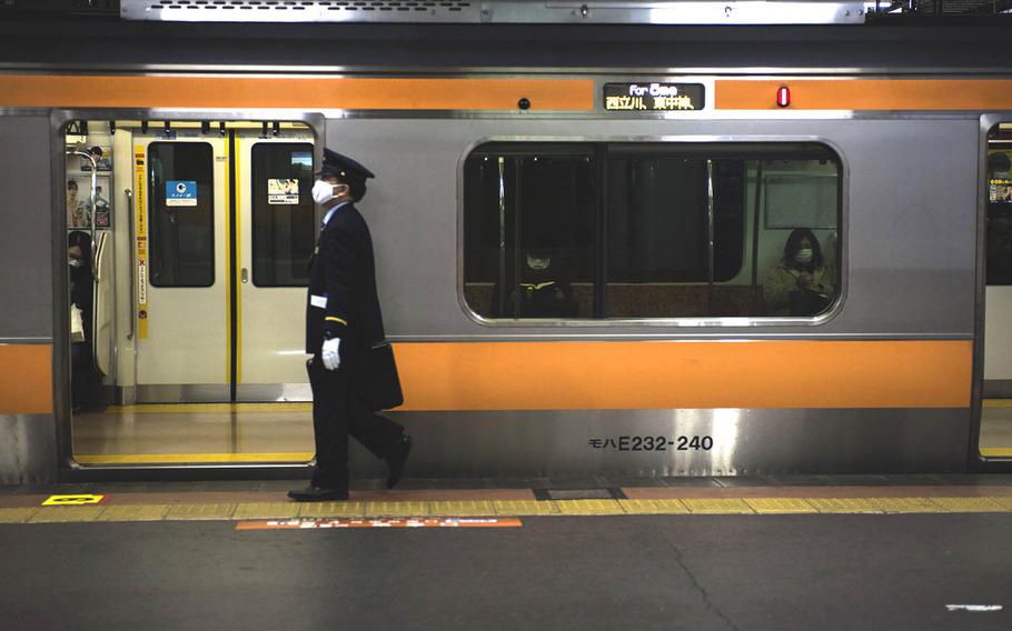 A commuter train prepares to depart Hachioji Station in western Tokyo, Tuesday, Feb. 2, 2021. 