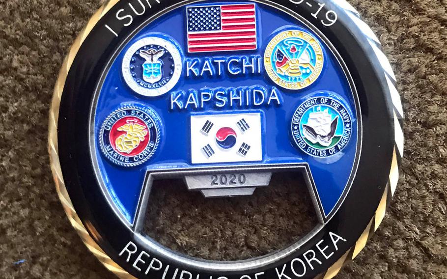 This challenge coin features the U.S. and South Korean flags, along with the phrases "Katshi Kapshida"(Go Together) and "I Survived COVID-19."
