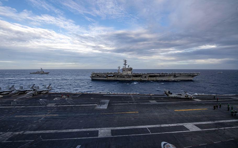 The aircraft carrier USS Theodore Roosevelt, foreground, steams alongside the aircraft carrier USS Nimitz in the South China Sea, Tuesday, Feb. 9, 2021. 