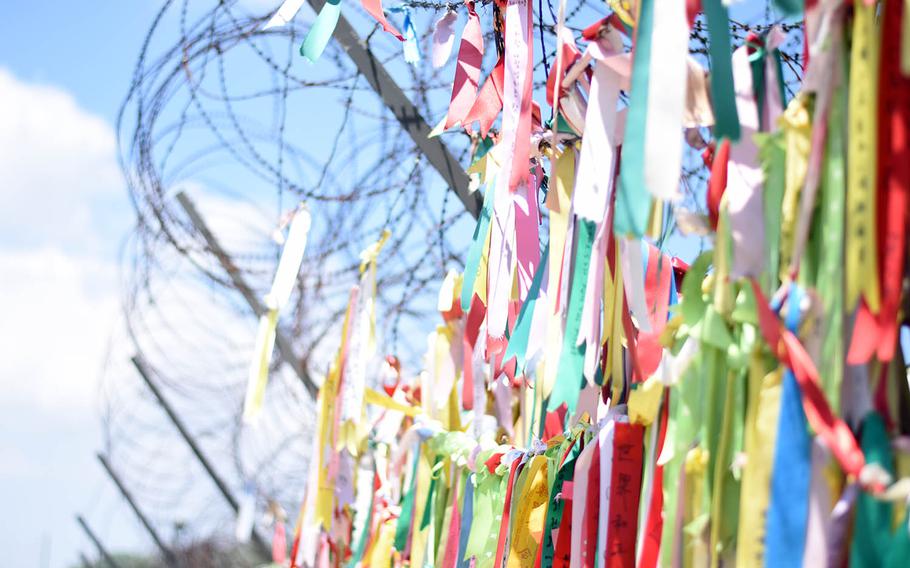 Prayer ribbons left by visitors wishing peace between North and South Korea hang from a security fence near the border in Paju, South Korea.