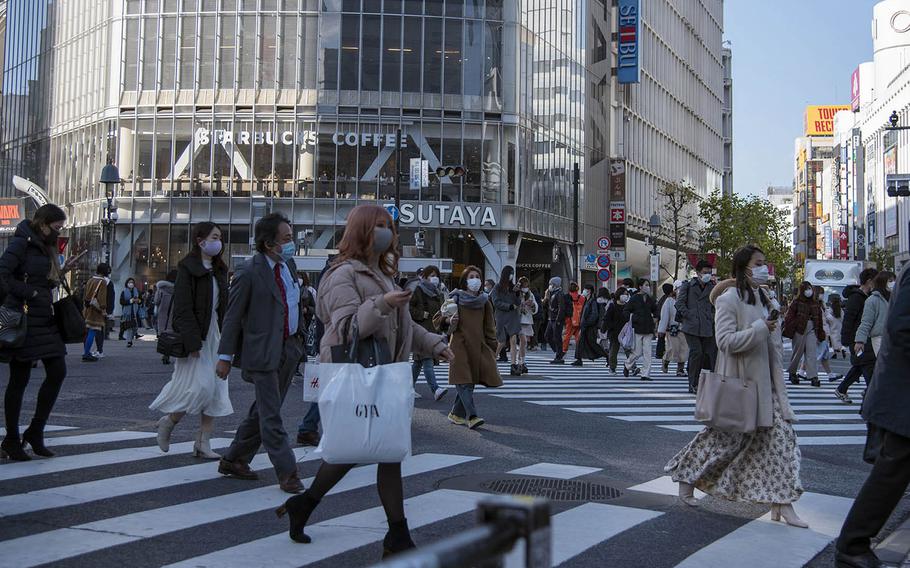 People wear masks as they cross the Shibuya Scramble in central Tokyo, Feb. 4, 2021. 