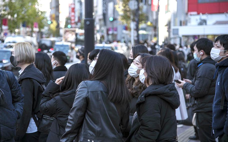 People wear masks as they stroll the crowded streets of Tokyo's Shibuya district, Feb. 4, 2021.