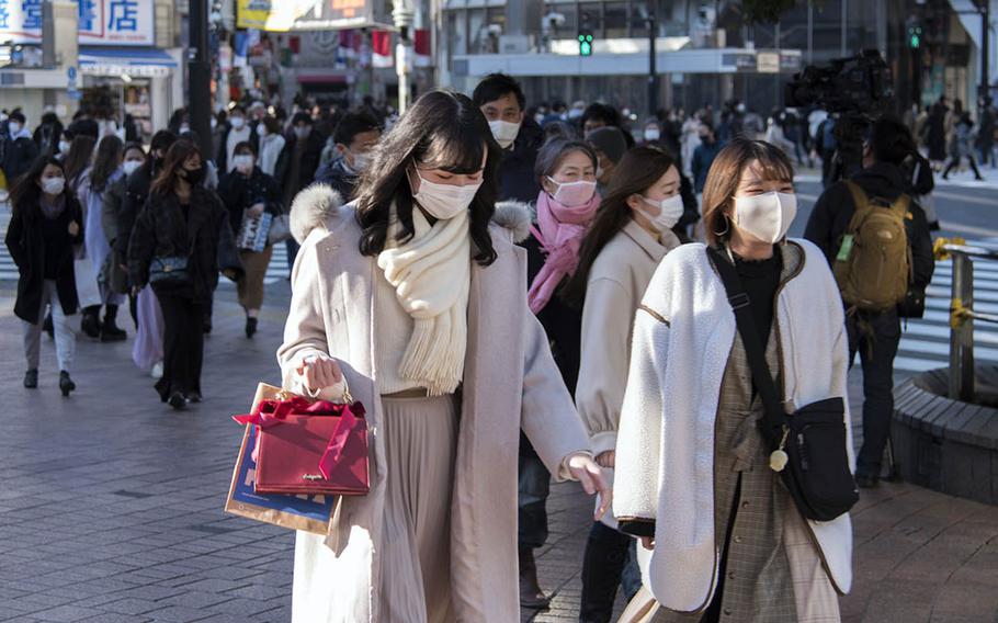 People wear masks to guard against the coronavirus while visiting Shibuya in central Tokyo, Feb. 4, 2021.