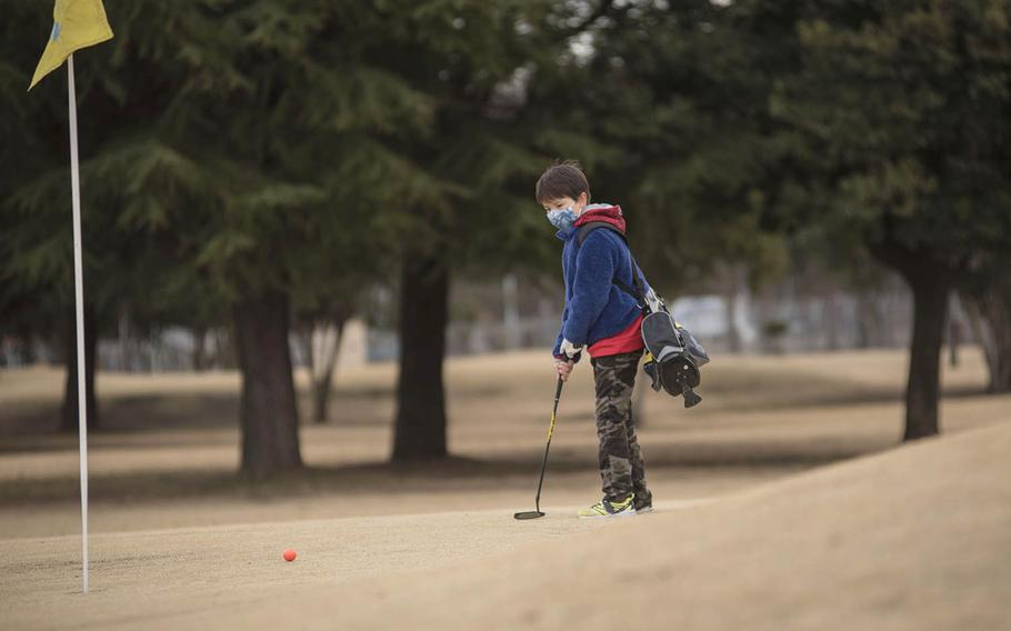 Junior golfer Jake Hughes putts on the Par 3 golf course at Yokota Air Base, Japan, Thursday, Feb. 18, 2021. 