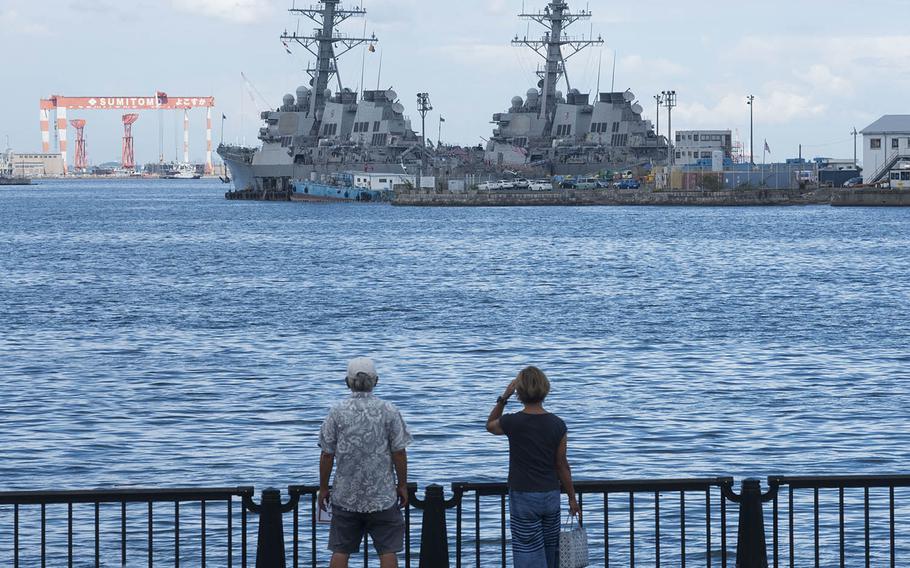 People check out U.S. Navy warships docked at Yokosuka Naval Base, Japan, Aug. 27, 2020.