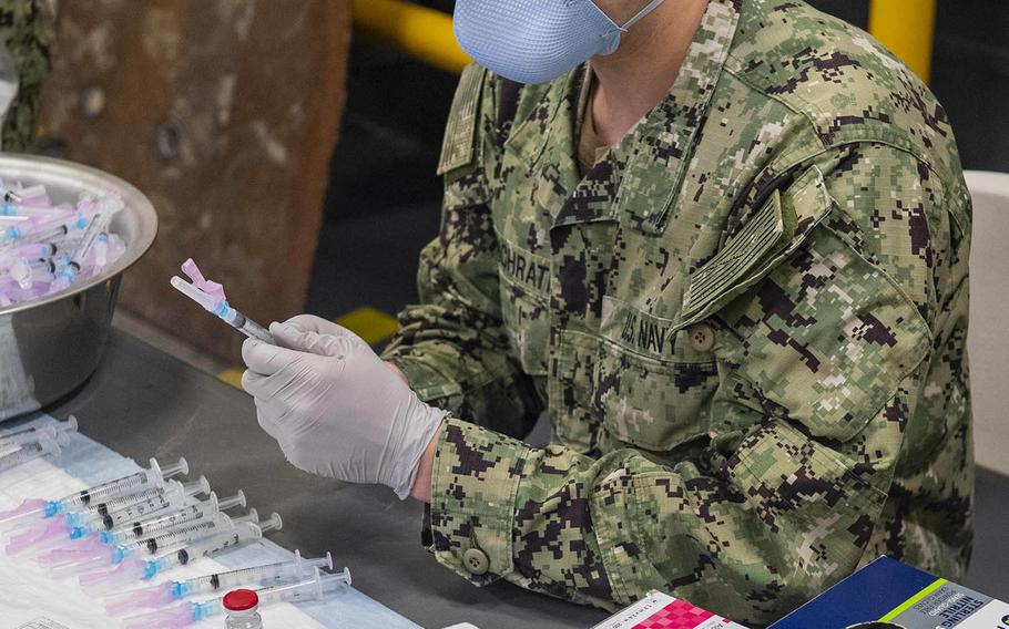 A Navy hospitalman fills syringes with the Moderna COVID-19 vaccine aboard the amphibious assault ship USS America at Sasebo Naval Base, Japan, Feb. 26, 2021.