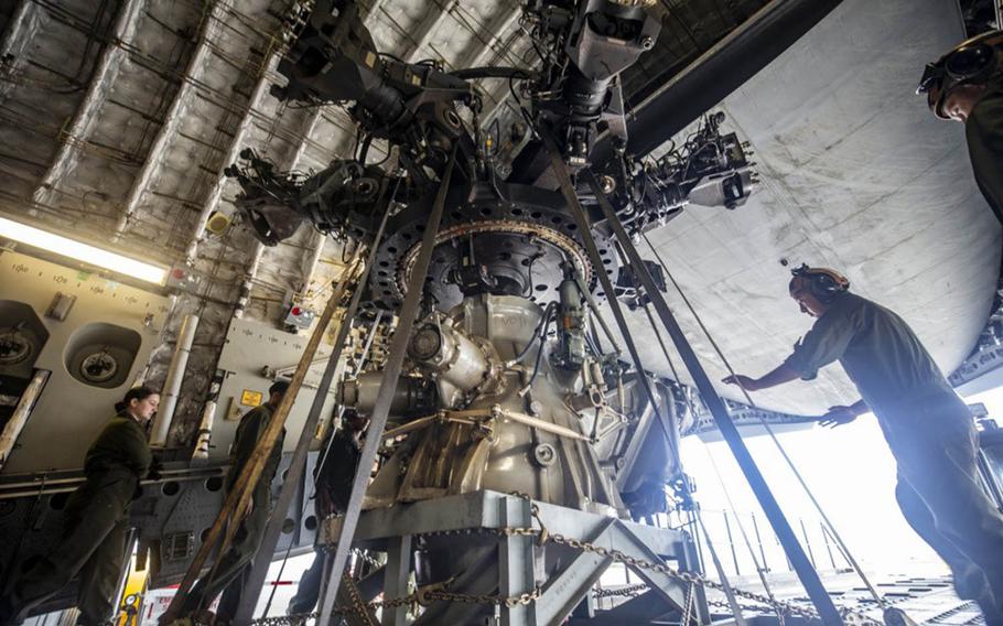 A CH-53E Super Stallion helicopter is loaded into an Air Force aircraft for transfer from Marine Corps Base Hawaii to Okinawa, Japan, March 4, 2021.