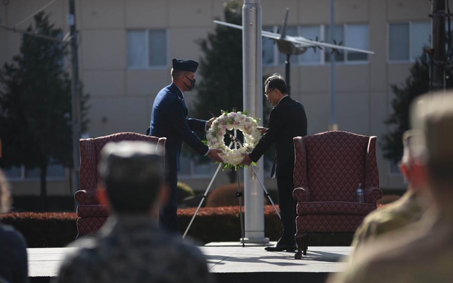 Col. Andrew Campbell, commander of the 374th Airlift Wing, and Takahisa Matsuda, director of the North Kanto Defense Bureau, place a wreath in honor of the victims of the Great East Japan Earthquake, during a ceremony at Yokota Air Base, Japan, Thursday, March 11, 2021. 