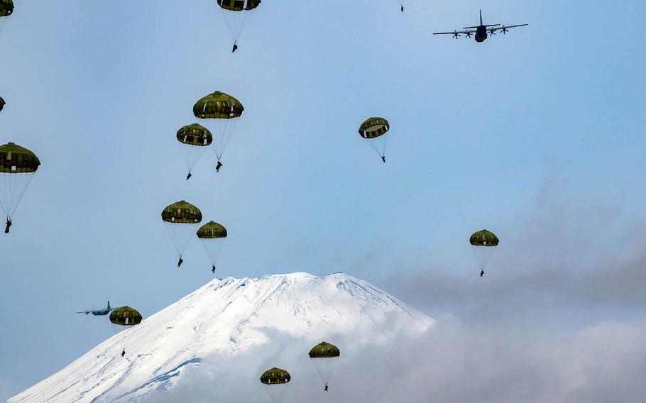 Japanese paratroopers jump from an Air Force C-130J Super Hercules at Combined Arms Training Center Camp Fuji, Japan, Tuesday, March 9, 2021.