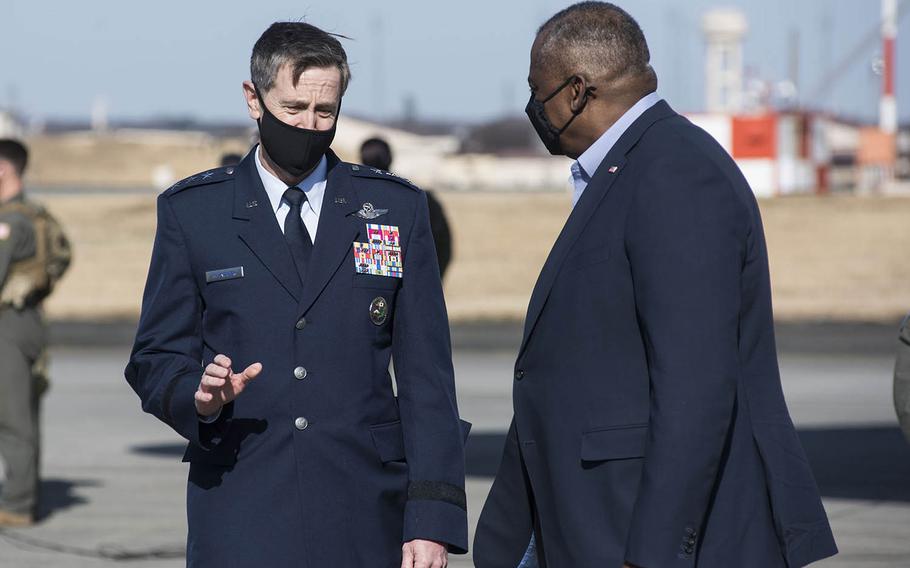 Defense Secretary Lloyd Austin, right, is greeted by the commander of U.S. Forces Japan, Lt. Gen. Kevin Schneider, at Yokota Air Base, Japan, Monday, March 15, 2021. 