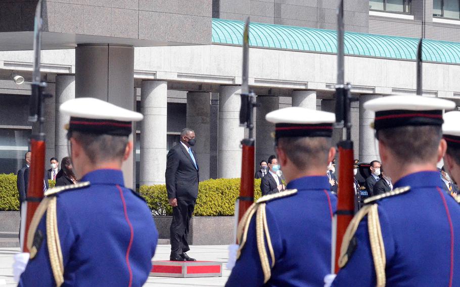 Secretary of Defense Lloyd Austin watches Japanese troops parade in front of the Ministry of Defense in Tokyo, Tuesday, March 16, 2021.