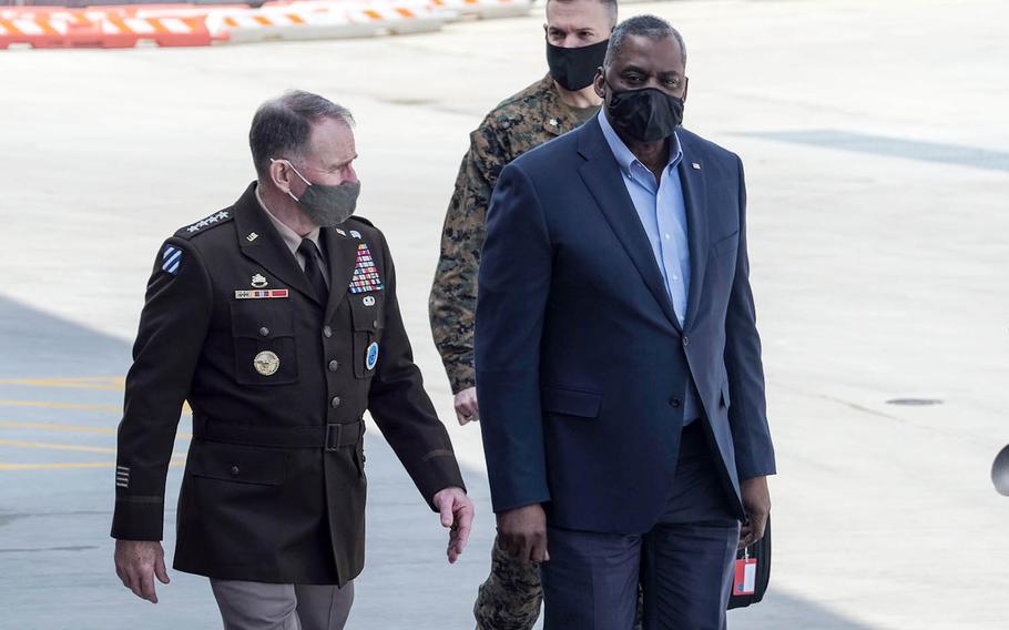 Defense Secretary Lloyd Austin walks with the commander of U.S. Forces Korea, Army Gen. Robert Abrams, after arriving at Osan Air Base, South Korea, Wednesday, March 17, 2021. 